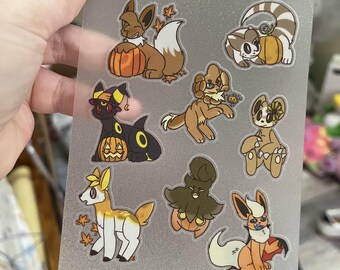 May include: A sheet of stickers featuring various cartoon characters with autumn and Halloween themes. The stickers include characters with pumpkins and fall leaves. The text "ALL HALLOW'S EEVEE" is printed at the top.