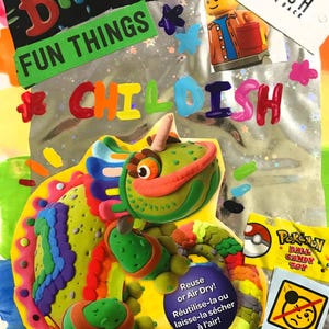 May include: A colorful, handmade birthday-themed collage with the words "Birthday," "Fun Things," and "Childish." It features a clay sculpture of a green and orange creature, along with a Pokemon candy toy.