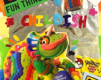 May include: A colorful, handmade birthday-themed collage with the words "Birthday," "Fun Things," and "Childish." It features a clay sculpture of a green and orange creature, along with a Pokemon candy toy.