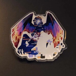 May include: A clear acrylic pin featuring a digital glitch art design of a winged creature with purple, red, and yellow wings. The creature is surrounded by a pixelated background.
