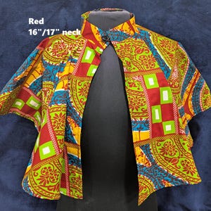 Puede incluir: Bolero estampado con cuello mandar&iacute;n. La tela presenta dise&ntilde;os geom&eacute;tricos y florales rojos, verdes, amarillos y azules. El texto "Red" y "16"/17" neck" es visible. Cuello: 40.6/43.2 cm.