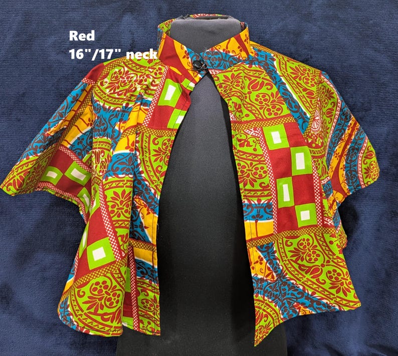 Puede incluir: Bolero estampado con cuello mandar&iacute;n. La tela presenta dise&ntilde;os geom&eacute;tricos y florales rojos, verdes, amarillos y azules. El texto "Red" y "16"/17" neck" es visible. Cuello: 40.6/43.2 cm.