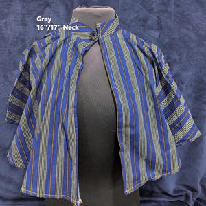 Puede incluir: Una camisa a rayas azules y blancas con cuello mandar&iacute;n. La camisa presenta rayas verticales en azul, blanco y dorado. El texto "Gray 16"/17" Neck" es visible en la imagen.