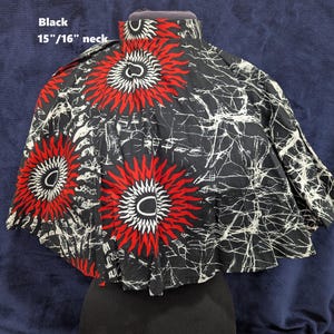 Puede incluir: Capa negra con cuello de 38 cm/41 cm, con un llamativo dise&ntilde;o de soles rojos y blancos sobre fondo negro. La capa tiene un cuello alto y una silueta acampanada.