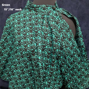 Puede incluir: Capa verde estampada con cuello alto, exhibida en un maniqu&iacute;. La tela presenta un dise&ntilde;o negro y verde azulado. El texto "Green" y "15"/16" neck" son visibles. Un accesorio de moda &uacute;nico.