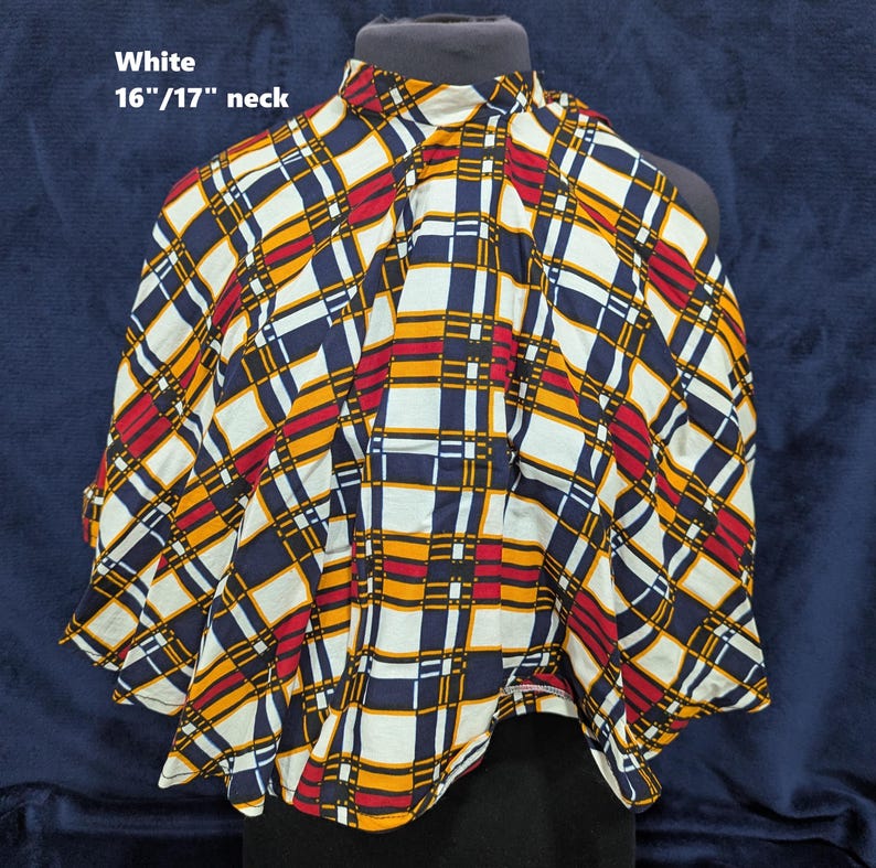 Puede incluir: Top blanco estampado, cuello 16"/17" (aprox. 41-43 cm). La tela presenta un dise&ntilde;o de cuadros en rojo, amarillo, azul marino y negro. El top se muestra en un maniqu&iacute;.