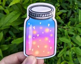 May include: A sticker featuring a jar design with a gradient of colors, including blue, purple, pink, and orange. The jar contains glowing lights and small white heart shapes. The jar has a silver lid and a white outline.