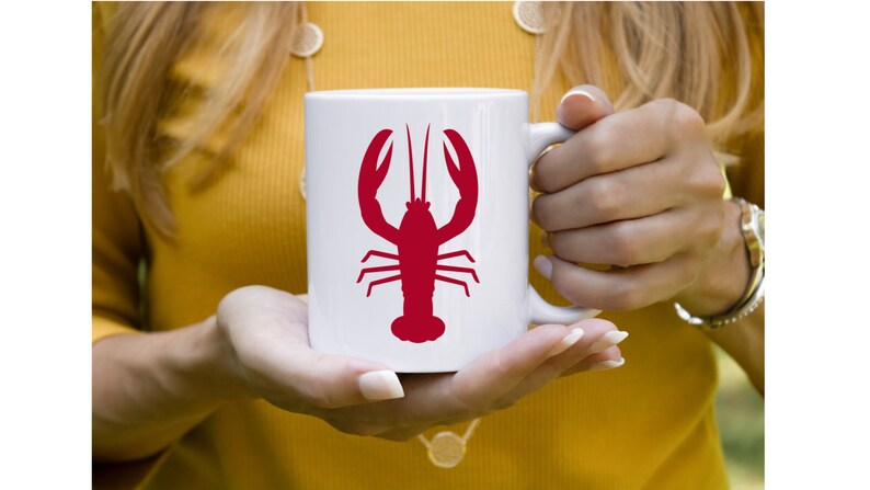 K&ouml;nnte beinhalten: Wei&szlig;e Keramiktasse mit einem roten Hummer-Silhouetten-Design.