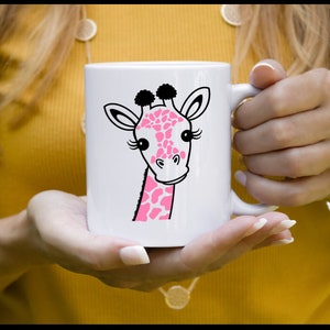 Puede incluir: Taza de cer&aacute;mica blanca con una ilustraci&oacute;n de jirafa de dibujos animados rosa y negra. La jirafa tiene pesta&ntilde;as y una nariz rosa.