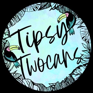 Puede incluir: Dise&ntilde;o circular con el texto "Tipsy Twocans" en escritura negra. El dise&ntilde;o presenta dos tucanes con picos amarillos y acentos rosas, rodeados por un borde de hojas tropicales en blanco y negro, sobre un fondo azul claro y verde.