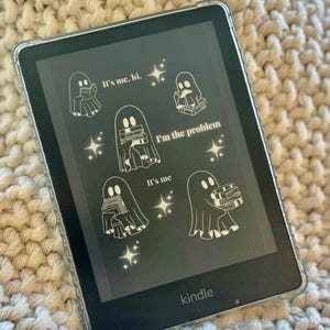 May include: A black and white illustration of a ghost holding a stack of books on a Kindle e-reader. The text on the screen reads "It's me. Hi. I'm the problem. It's me."