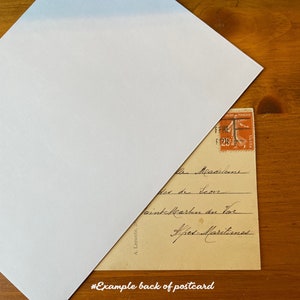 May include: The back of a vintage postcard with handwritten text in French. The text reads "Mesnilens, Place de l'Ecore, Point Martin du Vor, Ares-Martines". A French postage stamp is in the upper right corner.