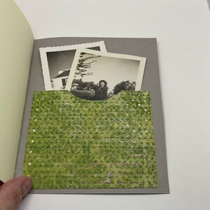 Puede incluir: Un &aacute;lbum gris con un bolsillo de patr&oacute;n verde. El bolsillo contiene dos fotograf&iacute;as en blanco y negro. Una foto muestra una casa y la otra muestra a una mujer de pie frente a una casa.