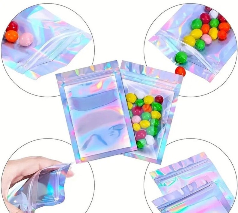 May include: A set of four iridescent holographic zippered pouches. The pouches are made of a clear plastic material with a holographic finish. The pouches are shown in different positions, including one with colorful candies inside.