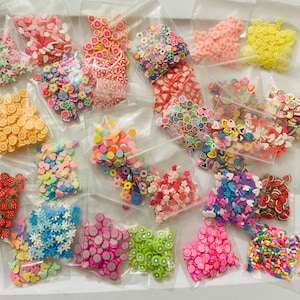 May include: Assortment of colorful sprinkles in various shapes and sizes, including hearts, stars, circles, and more. The sprinkles are packaged in clear plastic bags.