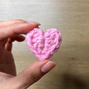 May include: A small pink crocheted heart.