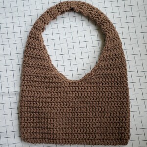 May include: A brown crocheted tote bag with a single strap.