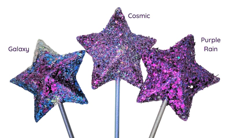 May include: Three glitter star wands with different color combinations: Galaxy, Cosmic, and Purple Rain. The wands are made of a silver metal stick with a star-shaped topper.