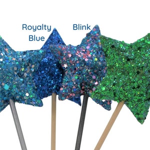 May include: Four glitter star wands with wooden sticks. The stars are in the colors: fairy blue, royalty blue, blink, and victory green.