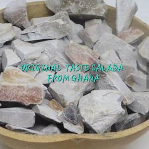 May include: A wooden bowl filled with light grey and white rock-like pieces. The text "ORIGINAL TASTE CALABA FROM GHANA" is printed on the rocks.