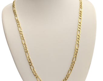 Pode incluir: Um colar de corrente Figaro dourado exposto em um manequim branco. A corrente apresenta um padrão de três pequenas ligações circulares seguidas por uma ligação oval alongada. O colar é uma peça de joalheria clássica.