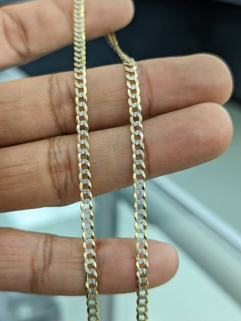 Pode incluir: Um colar de corrente curb de dois tons, ouro e prata. A corrente &eacute; feita de elos entrela&ccedil;ados e tem um acabamento polido.