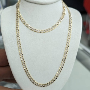 Pode incluir: Um colar de corrente de ouro com um design de corte de diamante. A corrente &eacute; exibida em um manequim branco.