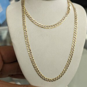 Pode incluir: Um colar de corrente de ouro com um design de corte de diamante. A corrente est&aacute; em um expositor branco.