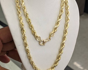 May include: A gold rope chain necklace with a lobster clasp.