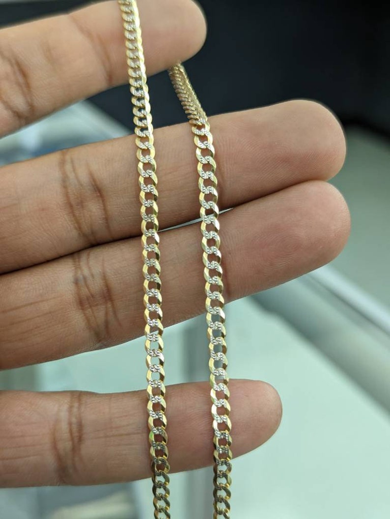 Pode incluir: Um colar de corrente de ouro com um design de dois tons. A corrente &eacute; feita de elos de ouro amarelo e branco alternados.
