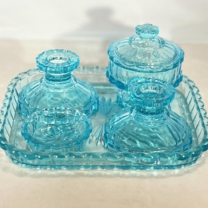 blue glass dressing table set Vibrant blue glass dressing table set by Czechoslovakian manufacturer Reich c1920s. 50. Full details and to buy https://t.co/q5ltocIe0F #annasartdeco #reichglass #artdecoglass #decoglass #dressingtableset #vanityset #blue #brightblue #deco #glass
