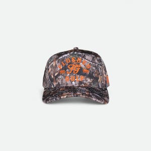 Peut inclure: Une casquette de baseball avec un motif camouflage dans des tons de marron, noir et gris. L'avant présente une inscription brodée en orange vif "FLUSHED FG GOLF" avec "EST." et "2021" de chaque côté du logo central "FG".
