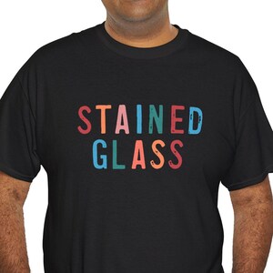 May include: A black t-shirt with the words "STAINED GLASS" printed in rainbow colors.