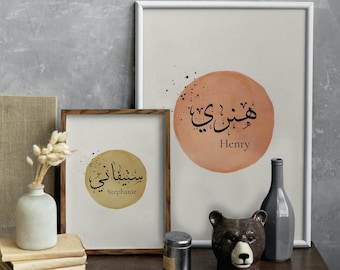 May include: Two framed wall art prints featuring circular watercolor-style backgrounds in terracotta and mustard yellow. Each print displays a name in both Arabic calligraphy and English text: Henry in terracotta and Stephanie in mustard yellow.