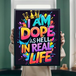 May include: A framed art print with the words "I AM DOPE AS HELL IN REAL LIFE" in vibrant colors. The text is in a bold, graffiti-style font, with a gold crown above the word "AM". The background is black.