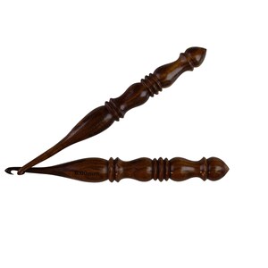 May include: Two wooden crochet hooks, one with a 10.00mm size marking. The hooks are brown with a dark wood grain and have a pointed tip.