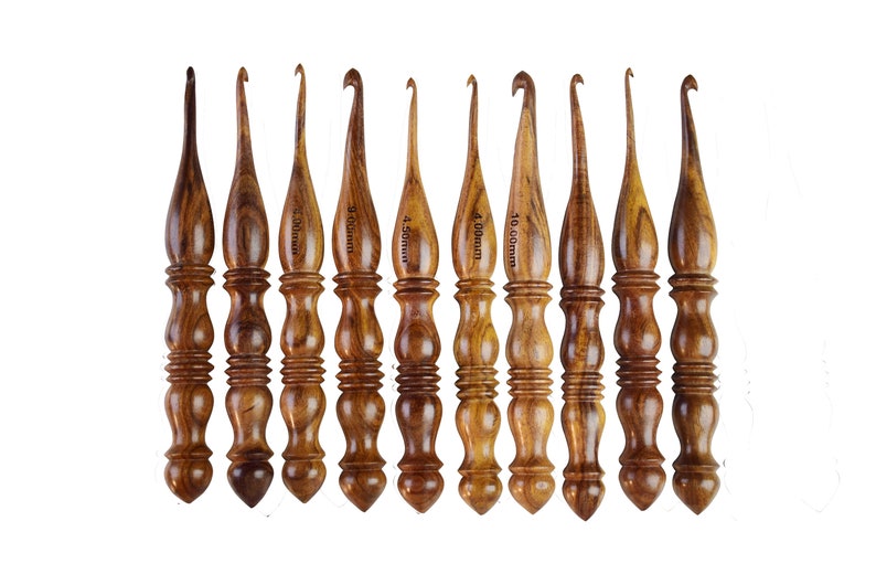 May include: Set of ten wooden crochet hooks in various sizes, ranging from 3.5 mm to 10 mm. The hooks are made of brown wood and have a smooth, polished finish.