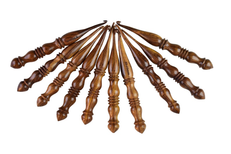 May include: Set of ten wooden crochet hooks in various sizes, ranging from 3.5 mm to 10.0 mm. The hooks are made of dark brown wood with a natural grain pattern.