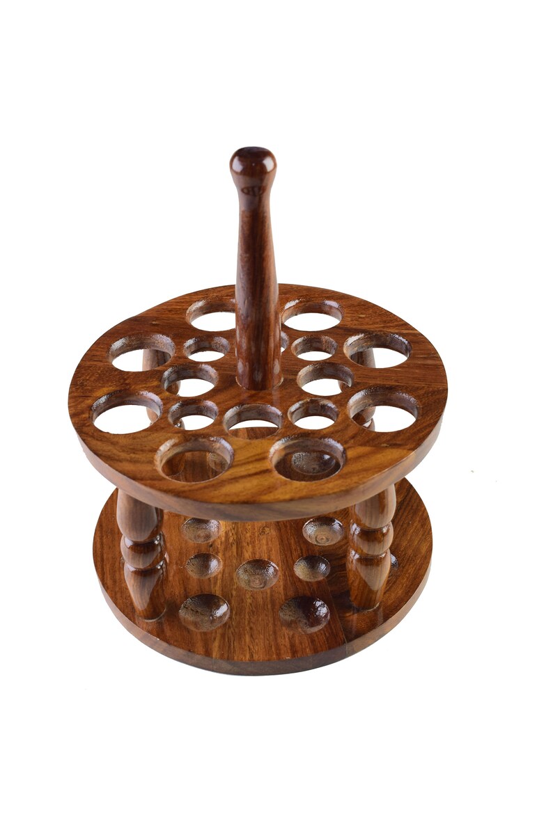 May include: A wooden stand with a central post and two tiers of circular holes, designed to hold a collection of items like paintbrushes or tools.