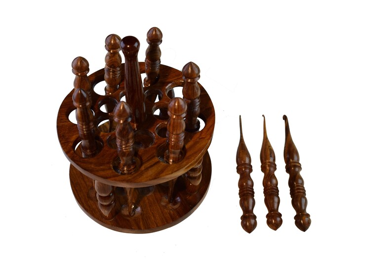 May include: A wooden spinning stand with 12 slots for holding crochet hooks. The stand is made of dark brown wood and has a smooth finish. Three additional crochet hooks are shown separately.