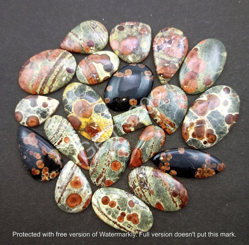 May include: A collection of 18 oval and teardrop shaped, polished, natural gemstone cabochons. The stones are a mix of green, brown, black, and red with a speckled and marbled pattern.