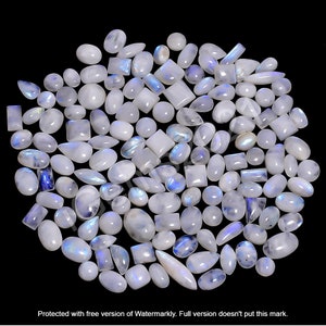 May include: A collection of white moonstone cabochons in various shapes and sizes, including oval, pear, and rectangular. The stones have a iridescent sheen with blue and white colors.