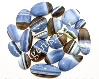 May include: A collection of 15 oval-shaped blue and brown opal cabochons. The stones have a variety of patterns and colors, including blue, brown, white, and black.