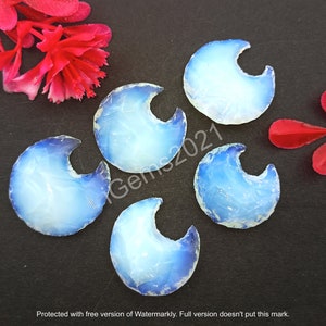 May include: Five blue and white opal cabochons shaped like crescent moons. The cabochons are arranged in a semi-circle on a black background.