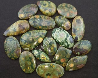 May include: A collection of 16 green, brown, and yellow ocean jasper cabochons in various shapes and sizes. The cabochons are polished and have a smooth, glossy finish.