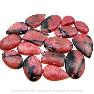 May include: A collection of 15 pink and black gemstone cabochons, cut in teardrop and rectangular shapes. The stones have a natural, polished finish.