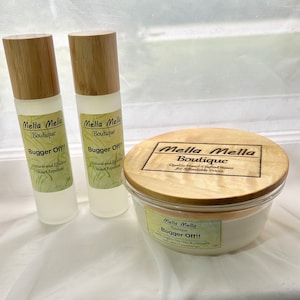 Könnte beinhalten: Zwei durchsichtige Glasflaschen mit Bambusdeckeln und Etiketten mit der Aufschrift "Mella Mella Boutique Bugger Off!! Natural and Effective Insect Repellent". Ein Glasgefäß mit einem Holzdeckel und einem Etikett mit der Aufschrift "Mella Mella Boutique Quality Hand-Crafted Items for Affordable Prices" und "Mella Mella Boutique Bugger Off!! Soy Organic Soy Wax & Citronella"