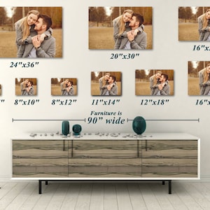 May include: A collection of canvas prints featuring a couple embracing, available in various sizes from 5"x7" to 24"x36". The prints are displayed on a white wall above a 90" wide cabinet. The image shows a warm, sepia-toned photograph.