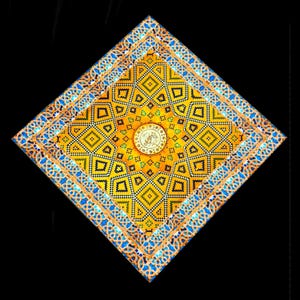 Può includere: Un elemento decorativo quadrato e ornato con un complesso motivo geometrico in giallo, blu e nero. Il design presenta motivi ripetuti a diamante e floreali, con un medaglione centrale contenente scritte arabe. Il pezzo è posto su uno sfondo nero.