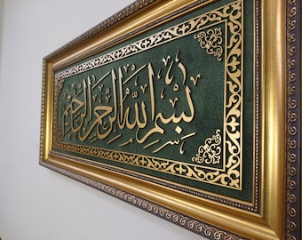 May include: A framed piece of Islamic calligraphy with gold lettering on a green background. The frame is gold with intricate designs.